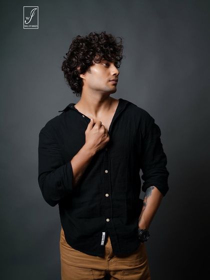 A closer portrait that focuses on the model's profile and curly hair, demonstrating versatility in posing.
