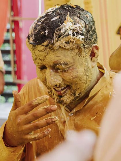 A close-up of the groom's face covered in turmeric, a raw and authentic capture of the Haldi ritual.