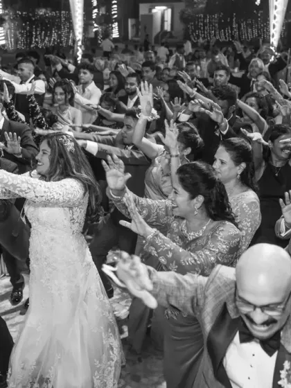 A black and white photo of the entire dance floor united in a synchronized move. It’s a powerful image that shows the collective energy and fun of the wedding party.