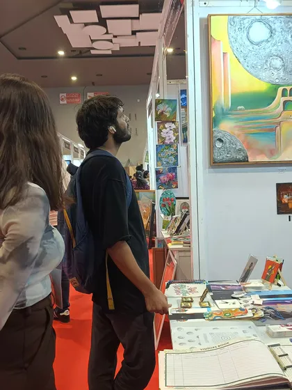 I love watching people connect with my art. This visitor is looking closely at my surrealist painting "Vo Shaam" at 'The Haat of Art'. Seeing my work resonate with others is the real win for me.