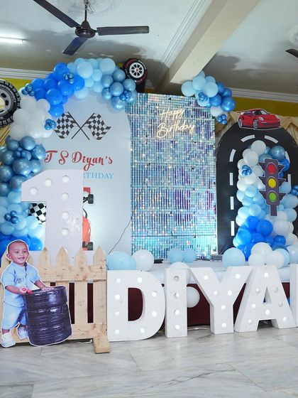 Ready, set, go! This car-themed first birthday party was a huge hit. We created a complete race track experience with custom backdrops, a shimmer wall, marquee letters, and fun details like traffic lights and tire props.