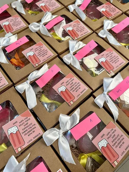 Rows of popsicle-themed gift boxes, all personalized with custom cards and ready for a party.