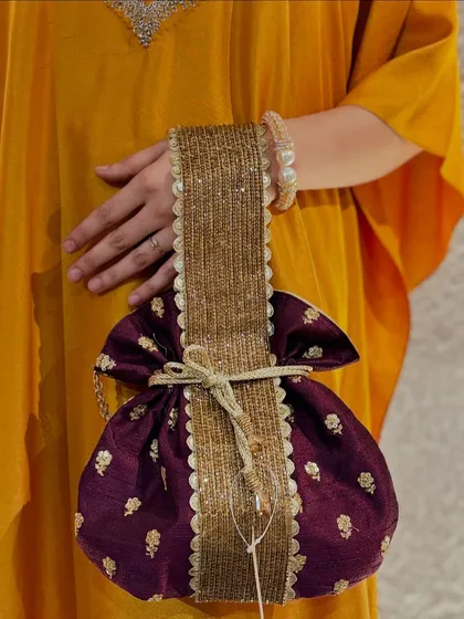 A full view of the majestic purple potli with its unique, wide handle, a true statement piece.