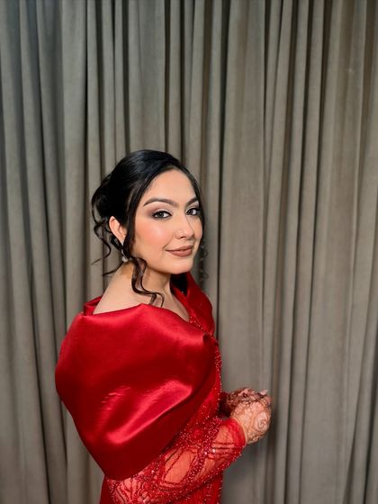 A side profile showing the elegant updo and the soft contouring of her makeup.