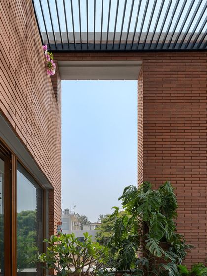 Different angles of the brick facade and pergola, showing how the design captures the sky. These framed views are intentionally designed to connect the residents with the open sky and surrounding nature.