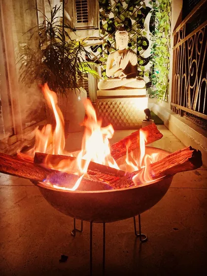 For those chilly winter evenings, I can set up a safe and stylish bonfire. This portable fire pit brings warmth and a mesmerizing glow to the balcony, creating a perfect gathering spot.