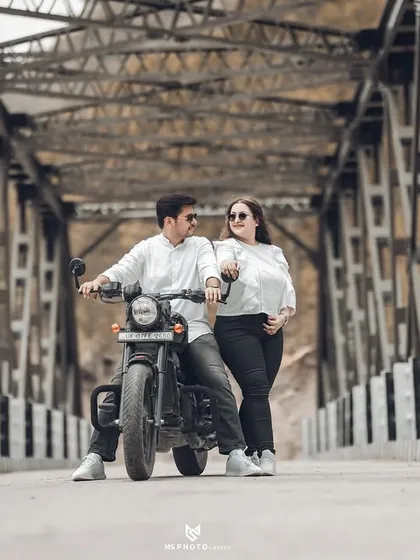Another fun, candid shot on the bridge. The couple's interaction with the bike adds a story-telling element to their pre-wedding photography.