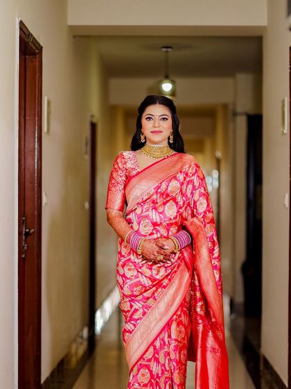 A full-length shot of the bride in the hallway, showcasing her complete look and the elegant drape of the saree.