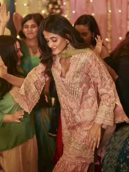 A candid moment of joy from Shivani Patil's mehendi. The flowy garara pants are perfect for dancing the night away.