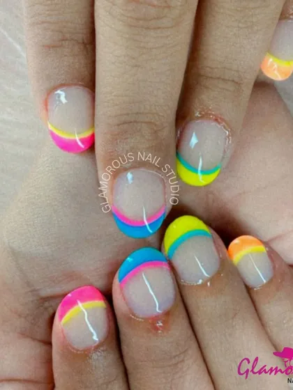 A playful and colorful design featuring layered, multi-colored French tips in shades of pink, yellow, blue, and orange.