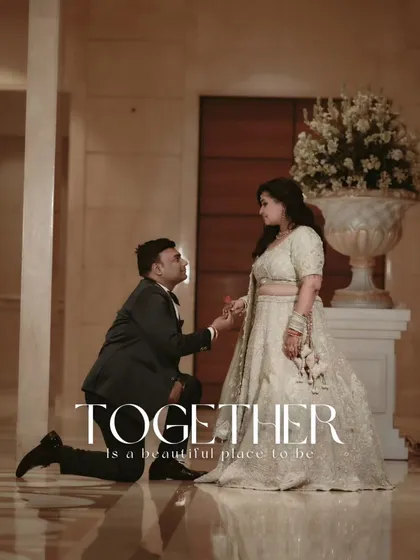 Gagan gets down on one knee to propose to Shalini in a grand, marble-floored hall, a timeless romantic gesture.