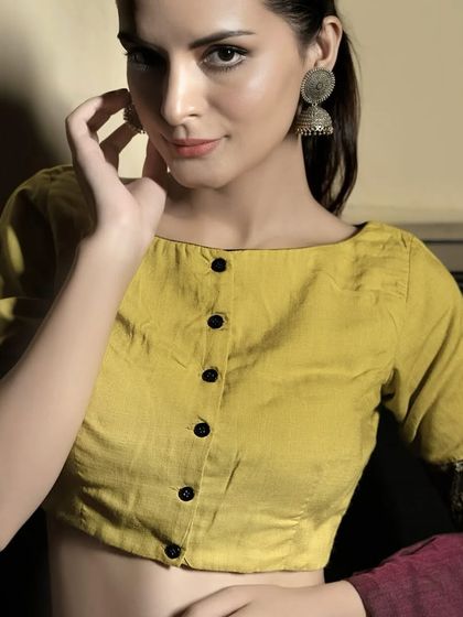 A full view of the yellow cotton boat neck blouse. The front button-down detail and simple silhouette make it a versatile piece for everyday wear.