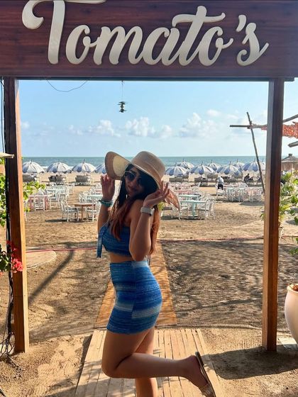 A fun and playful pose at the entrance of Tomato's beach shack in Goa. This captures the fun and carefree vibe of a beach vacation.