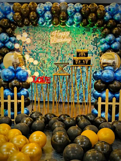 Another look at the popular blue, black, and gold birthday theme. The floor is filled with balloons, making the entire space feel festive and ready for a party.