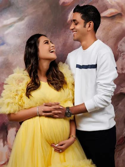 The pure, unscripted joy between two people about to start their family. I love capturing these candid moments of laughter and connection. Here, this couple shines in our vibrant yellow tulle gown against a soft, artistic backdrop, creating a memory filled with warmth and happiness.