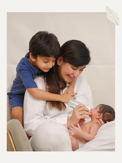 A beautiful family moment as an older brother watches his mother feed the new baby. It’s a perfect example of how we capture authentic, unposed interactions.