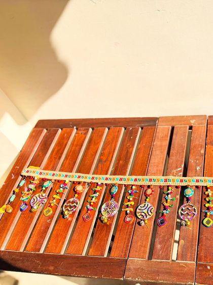 This is my 'Rang-Tarang' toran, a vibrant mix of everything I love: ghungroos, bells, buttons, and beads of all kinds. It’s a true festival of colors laid out in the sun.