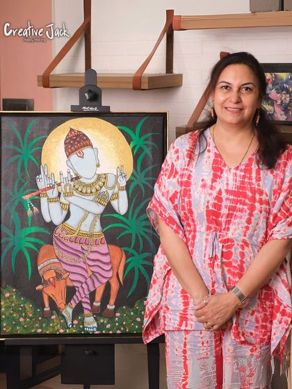 A student stands proudly next to her large canvas depicting a traditional Indian deity, a complex and beautiful piece she created in my advanced class.