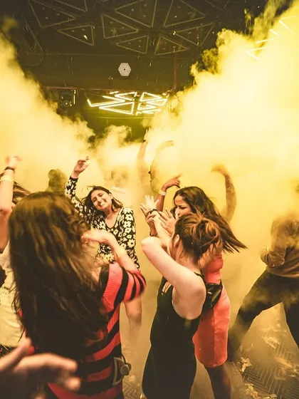 I love using smoke and lighting to transform a venue. Here, the dance floor at Club Illusions is immersed in a cloud of yellow smoke, creating a unique and electric atmosphere.