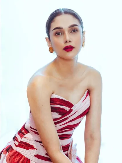 A close-up portrait in the Gauri and Nainika gown, highlighting the elegant strapless neckline and bold red lip.