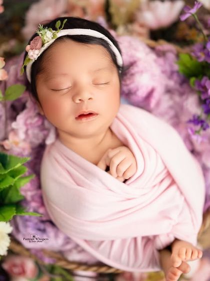 Another angle from the floral basket setup, showing the baby's tiny feet peeking out from the swaddle. It is these little details that make your newborn's portraits so special.