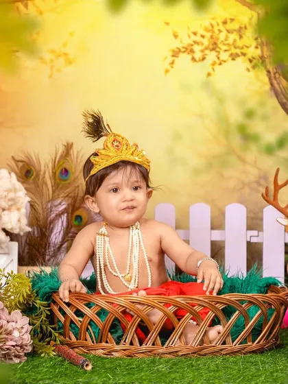 Celebrating tradition with a divine little Krishna photoshoot. I provide the complete setup, including the costume, peacock feather crown, and an enchanted garden backdrop, to create a truly special portrait for Janmashtami or any occasion.