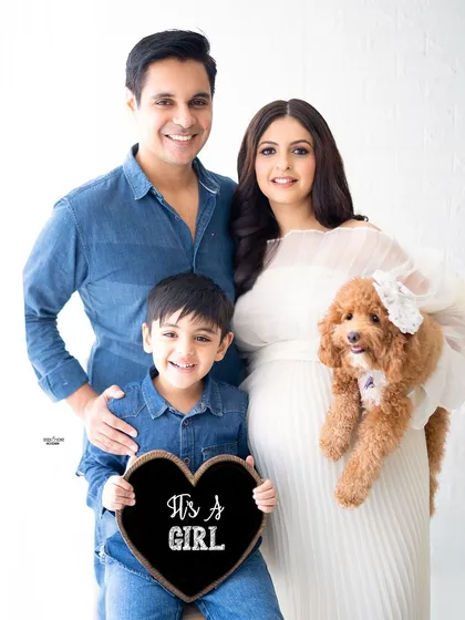 The whole family is here, including the fur baby. This is such a happy and complete family portrait, announcing they're expecting a girl.