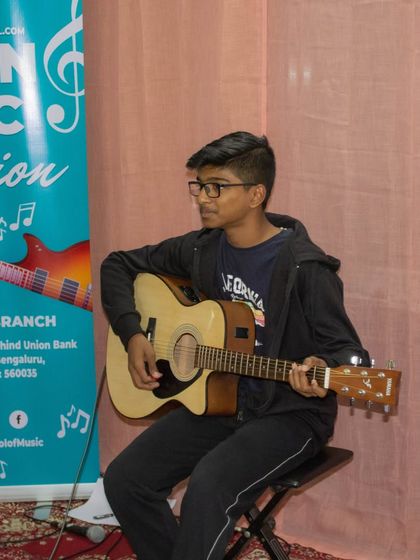 Another student performing on an acoustic guitar at our Sarjapur open mic event.