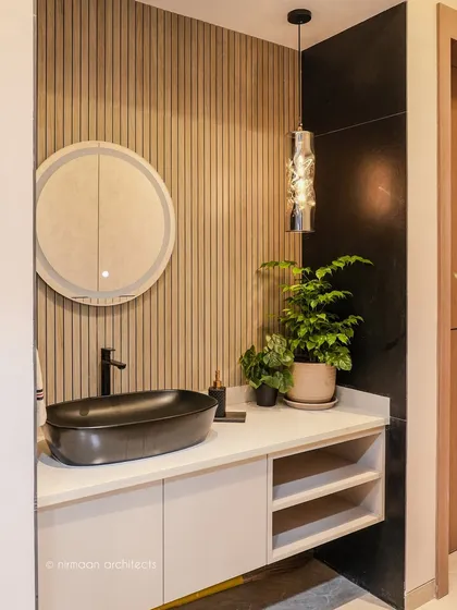 Even the smallest details matter. This wash basin area showcases our commitment to quiet luxury, featuring a stylish black vessel sink, fluted wood paneling, and elegant pendant lighting. It’s a functional space designed to feel like a small, personal retreat.