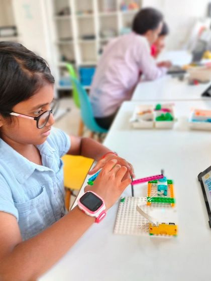 Focused and engaged, this student is programming her LEGO creation. Our summer camps provide the tools and guidance for kids to explore their passion for technology.
