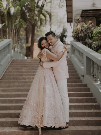 A warm, candid hug captured on the stairs, showing a moment of genuine affection and happiness.