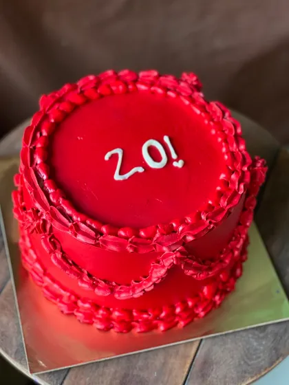 A vibrant, all-red cake to celebrate a 20th birthday. The vintage-style piping gives it a unique, dramatic look.