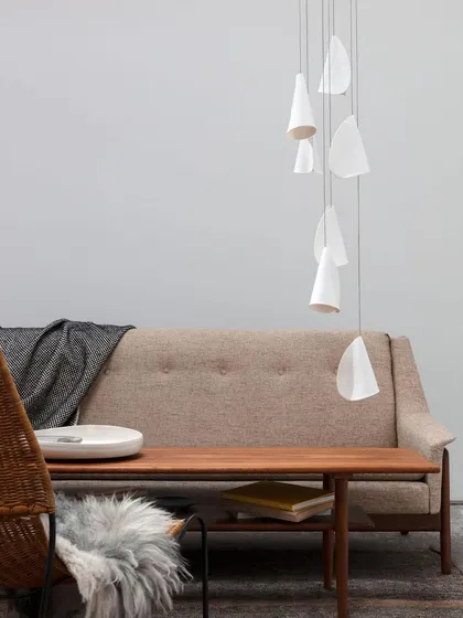 A minimalist arrangement of the Bocci 21 series in a serene living space. The simple, organic forms of the pendants complement the natural materials and calm color palette.