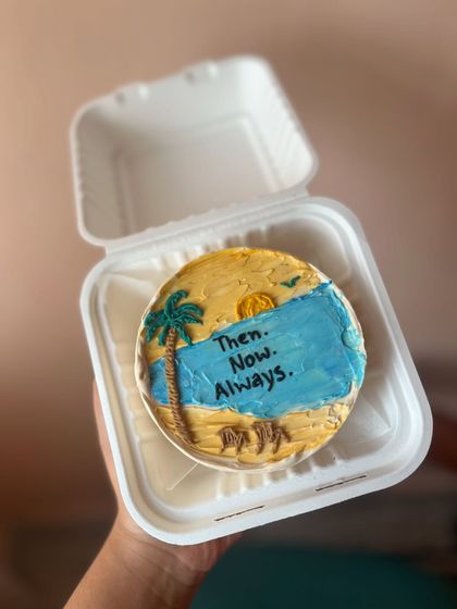 A beach-themed bento cake that tells a story. I used buttercream to create a scene with the ocean, sand, and a palm tree, with the words "Then. Now. Always."