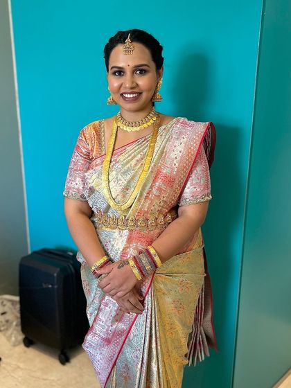 A full-length portrait showing how the makeup, hairstyle, and saree come together for a complete, elegant look. The dewy skin finish gives her a healthy, natural glow.