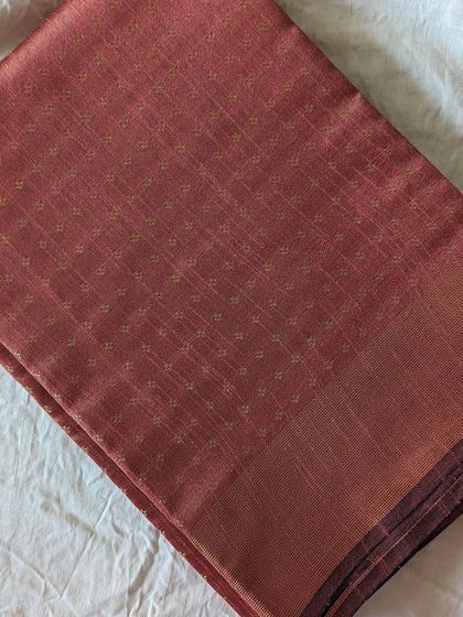 A beautiful onion pink semi raw silk saree. The color is soft and feminine, while the fabric has a rich, textured feel.