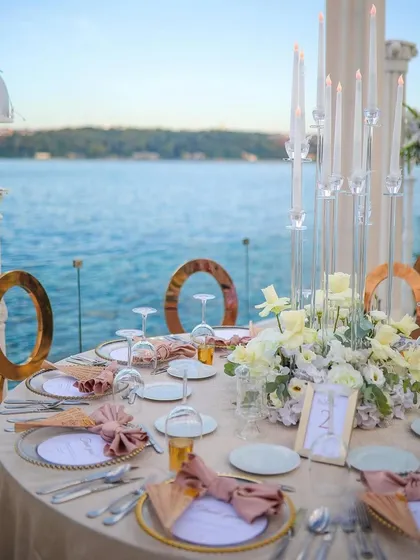 Another view of the seaside dining setup, showing the elegant place settings and the breathtaking view that guests can enjoy.