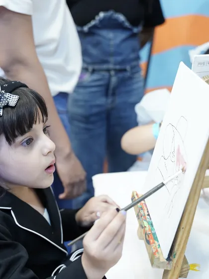 A young girl concentrates on her masterpiece at our canvas painting station. We can arrange for creative activities to keep all guests engaged.