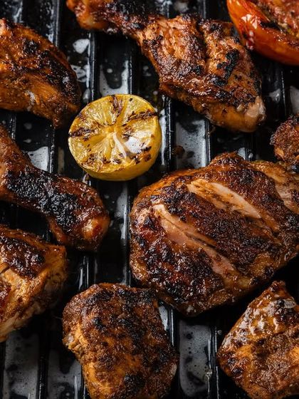 A variety of grilled meats and vegetables, shot on a grill plate for Punjab Grill to showcase their barbecue offerings.