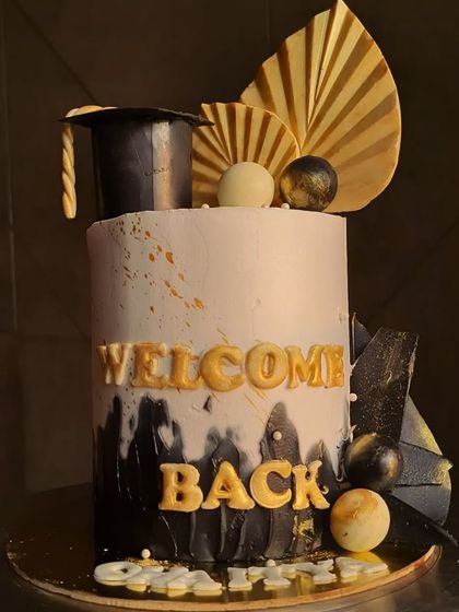 The graduation theme cake from another angle, showing the chocolate sails and graduation cap topper.