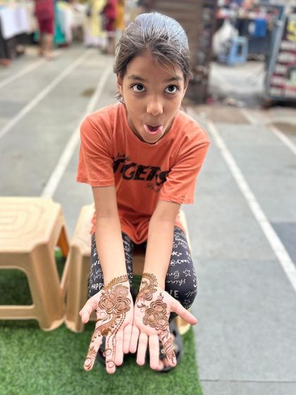 This young client is showing off her beautiful floral mehandi with a big, happy expression. I love creating designs that kids enjoy.