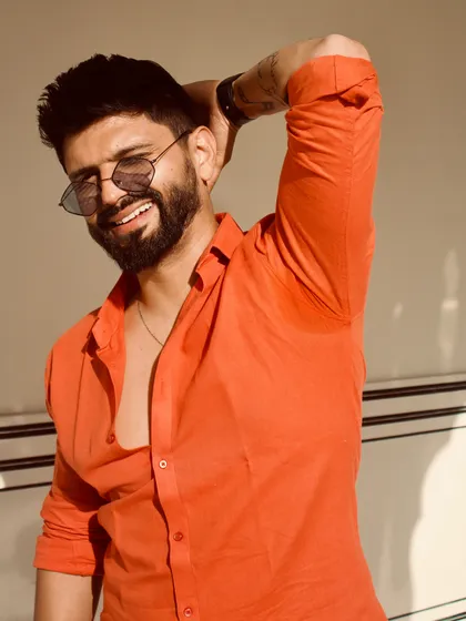 A happy, smiling shot in the orange shirt, capturing a moment of pure joy and confidence.