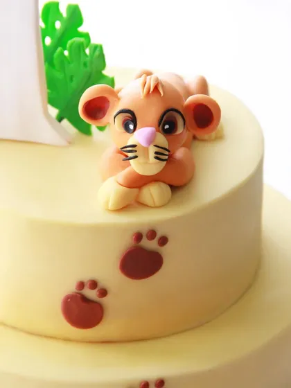 A close-up of the adorable, handcrafted Simba topper, ready to pounce.