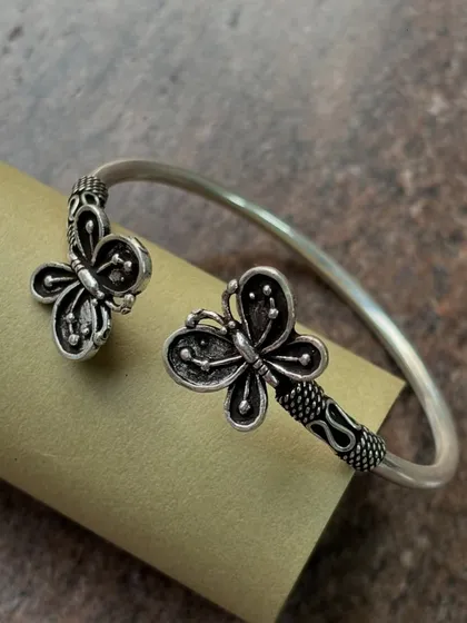 A delicate adjustable silver cuff bracelet featuring a butterfly design. The oxidized details on the wings add depth, making it a charming accessory for daily wear.
