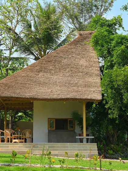 The reception building for the Fireflies Resort in Kabini, designed with a traditional thatched roof and bamboo columns to create a rustic and welcoming first impression.