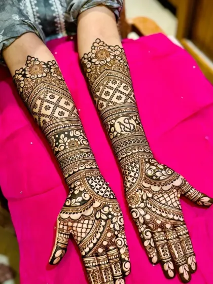 A personalized bridal design with the couple's initials, surrounded by intricate patterns. This is a great way to make your wedding mehndi truly your own.