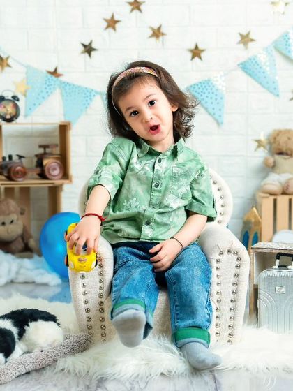 Exploring the world, one toy at a time. This two-year-old boy is full of expression and curiosity in this fun, travel-themed setup.