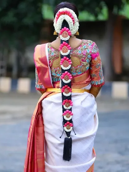 The back of the blouse is just as important as the front. This design features intricate embroidery that complements the bride's traditional South Indian floral hair arrangement, ensuring she looks stunning from every angle.