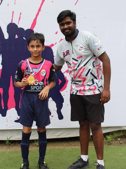 A young player receiving his medal from a coach, highlighting the supportive atmosphere of the event.