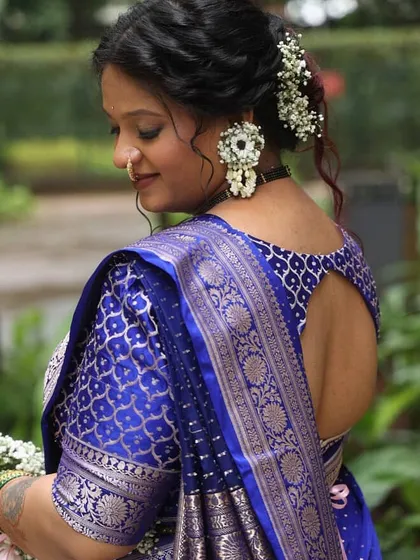 A close-up view of the back, showcasing the intricate floral earrings and hair accessories made from baby's breath and other delicate white flowers.